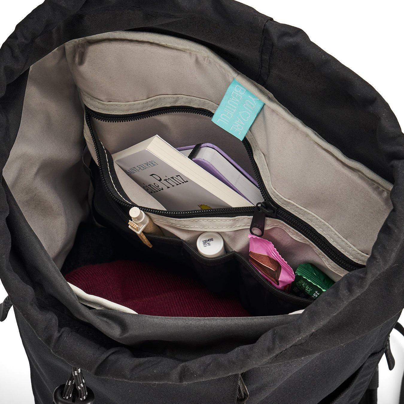 Ela Mo™ Everywhere Daypack | Black. Grauer Innenbereich des Rucksacks mit verschiedenen Alltagsgegenständen darin.