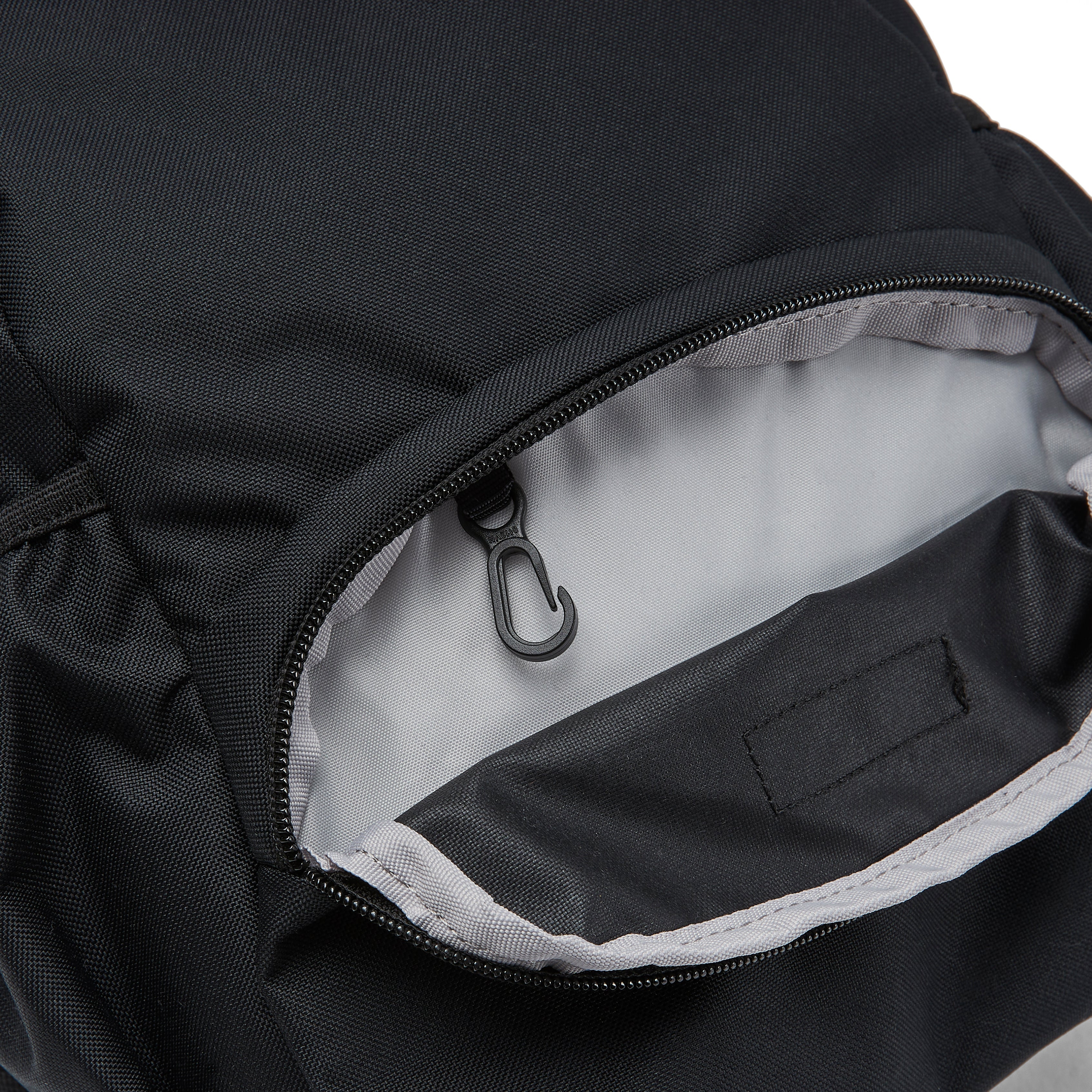 Ela Mo™ Mini Rucksack | Schwarz. Innenbereich des Außenfachs mit integriertem Schlüsselanhänger.