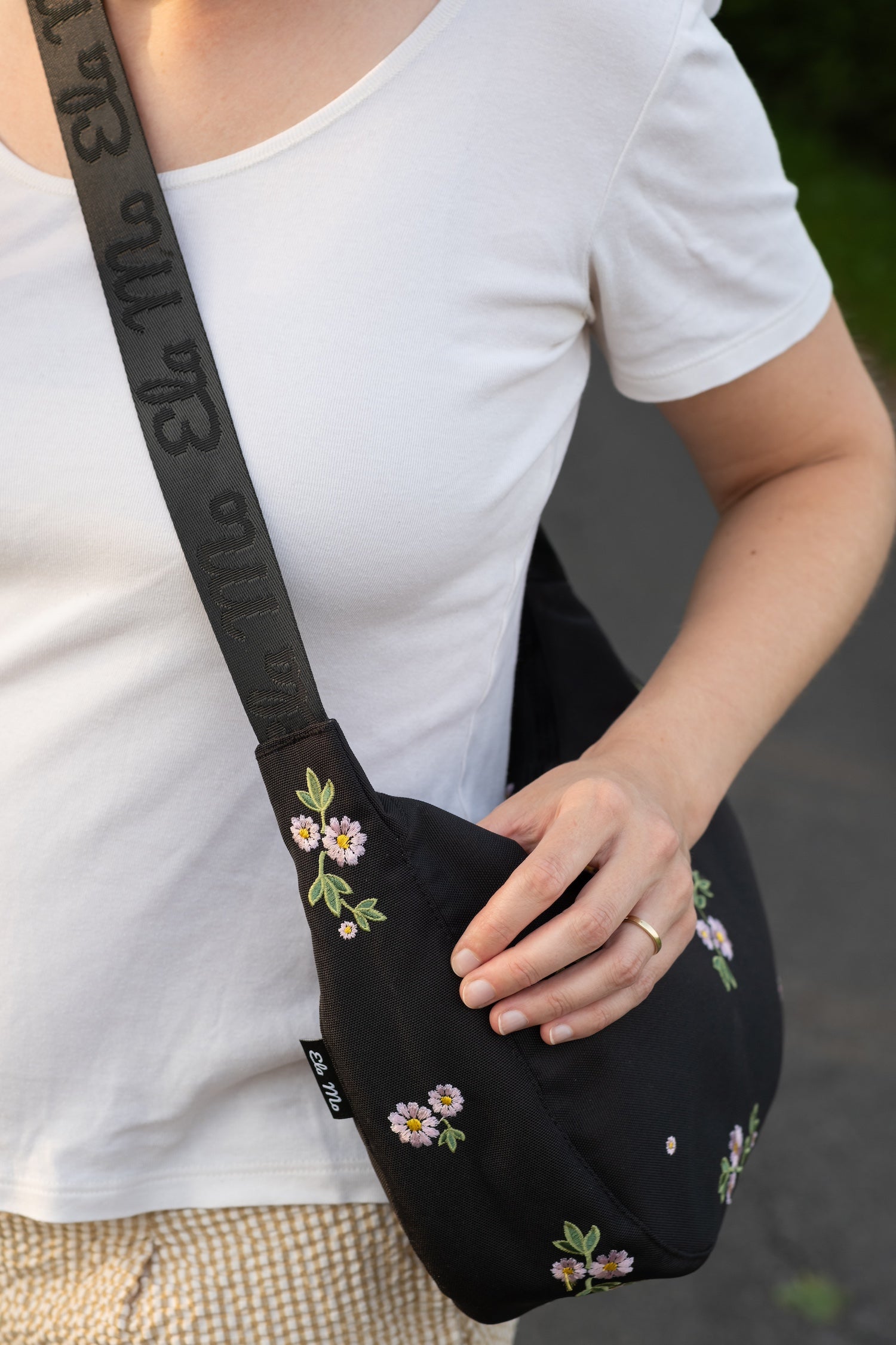 Ela Mo™ Moon Bag | Embroidery Edition Upsy Daisy. Eine Frau mit der Tasche auf der Wiese – alltäglicher Lifestyle.