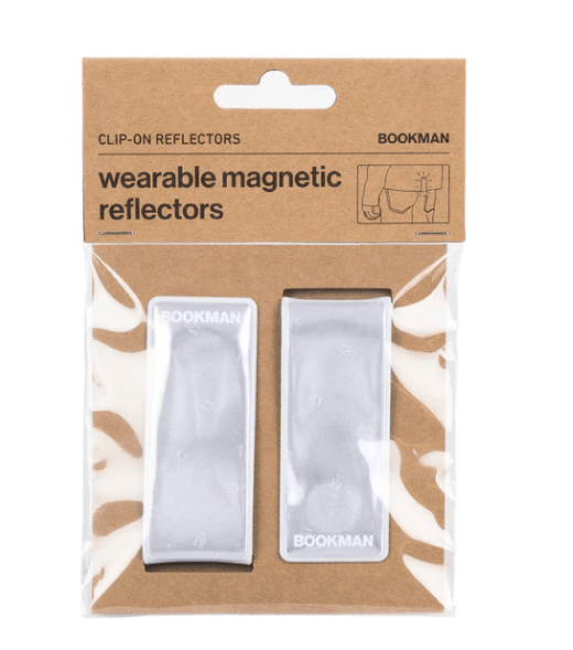 Ela Mo™ x BOOKMAN Reflektorclips. Reflektorclips verpackt auf weißem Hintergrund.