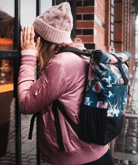 Ela Mo™ Rolltop Rucksack | A Rose. Eine Frau mit dem Rucksack auf dem Rücken – alltäglicher Lifestyle.