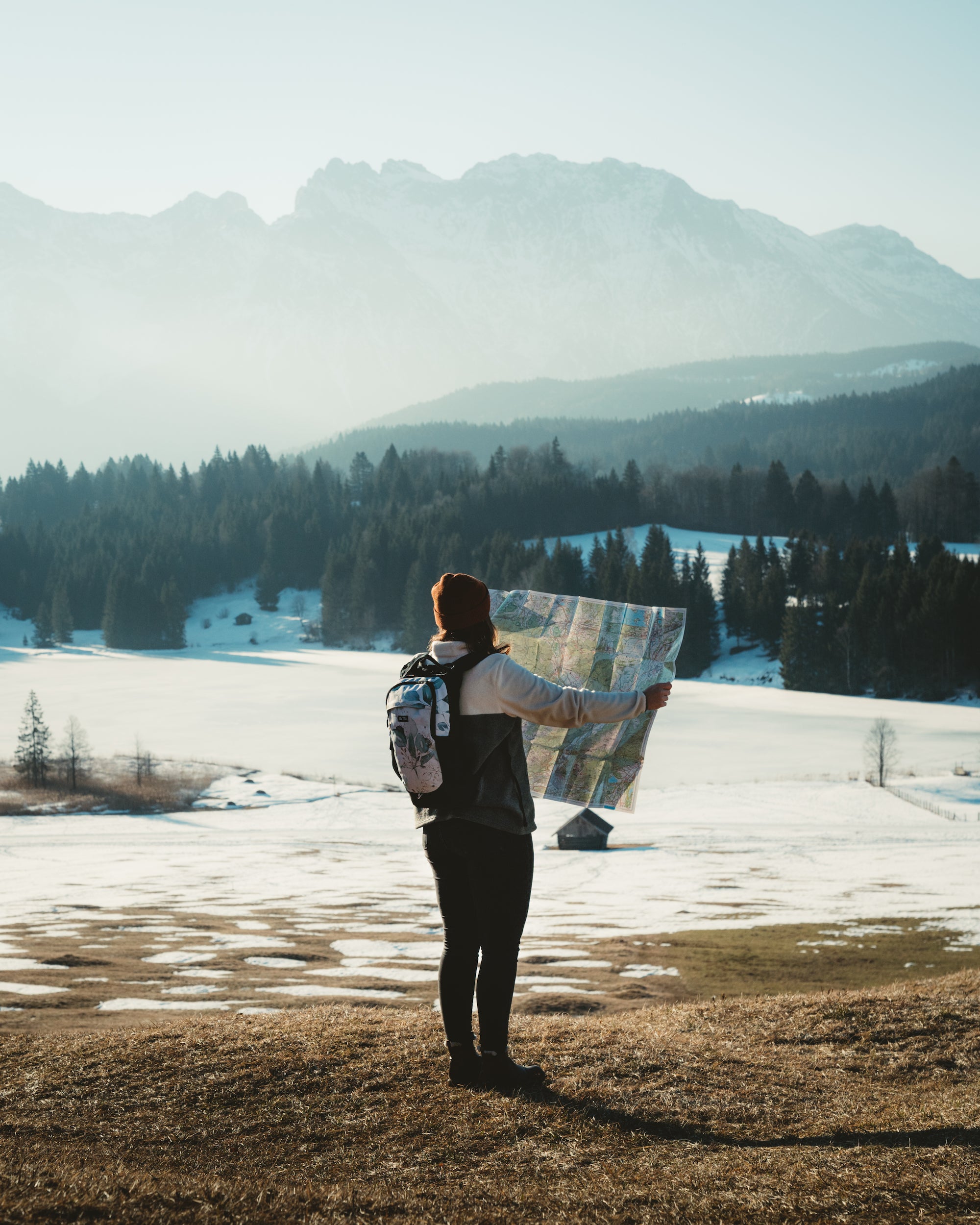 Ela Mo™ Flow Rucksack | Waterleaf Gold. Eine Frau mit dem Rucksack auf dem Rücken im Freien.