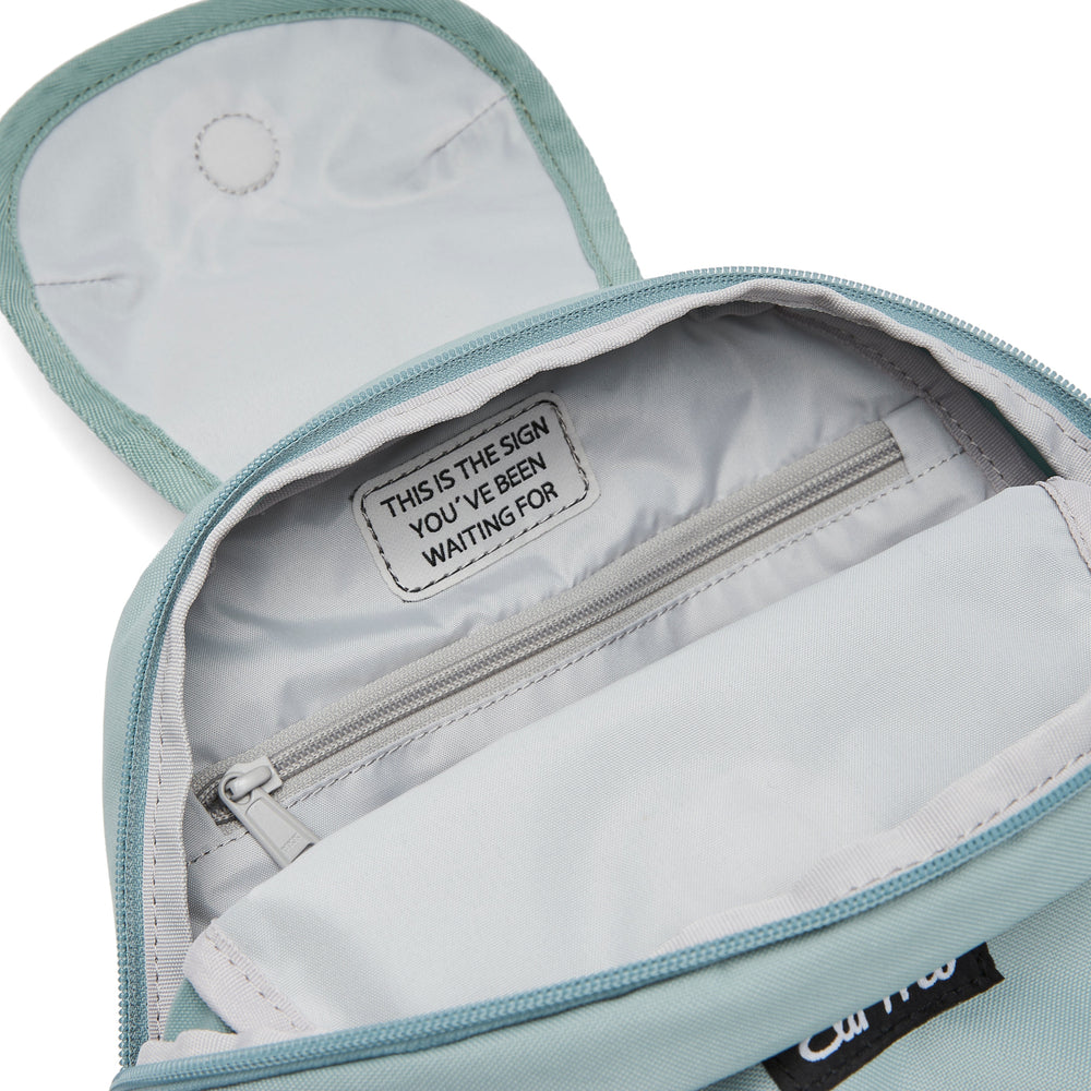 Ela Mo™ Mini Rucksack | Old Mint. Hellgrauer Innenbereich des Rucksacks mit kleinem Fach und Reißverschluss.